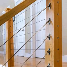 an image of a wooden stair rail with metal bars on the top and bottom part