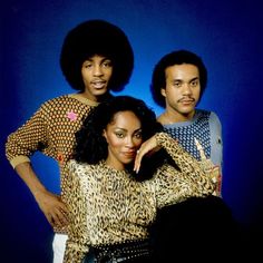 the jacksons posing for a photo in front of a blue background with their arms around each other