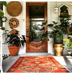 the front door is decorated with plants and rugs