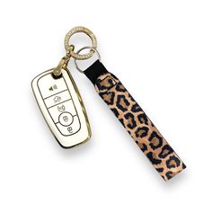 an animal print key chain with a remote control on it's side, and a leopard print lanyard