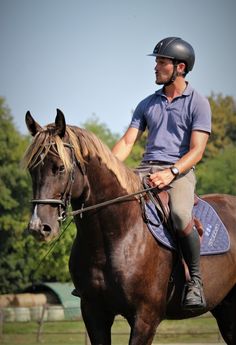 a man riding on the back of a brown horse