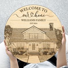 a person holding up a personalized wooden plate with a house on the front and side