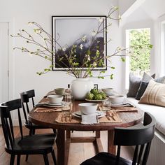 a dining room table with plates and bowls on it