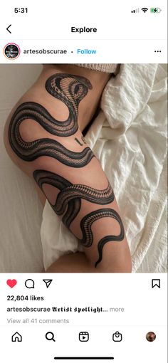 a person laying on top of a bed with a snake tattoo on their arm and leg