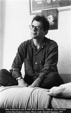 a black and white photo of a man sitting on a bed