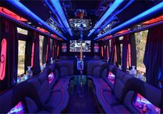 the inside of a party bus with purple couches and neon lights on the ceiling