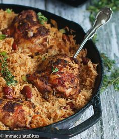 chicken and rice in a skillet with a spoon on the side, ready to be eaten