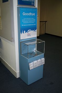 a display case in the middle of a room with blue carpeting and white walls