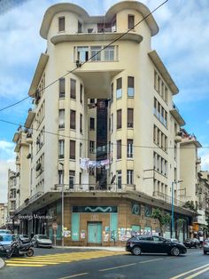 an apartment building on the corner of a street with cars parked in front of it