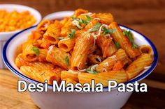 two bowls filled with pasta on top of a wooden table