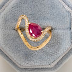 a gold ring with a pink stone and diamonds