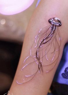 a small jellyfish tattoo on the arm