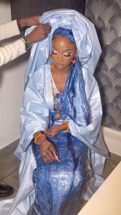 a woman sitting on top of a blue chair