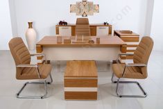 an office desk with chairs and a vase on the wall behind it in a white room