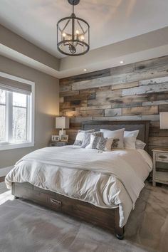 a large bed sitting under a window next to a wooden headboard in a bedroom