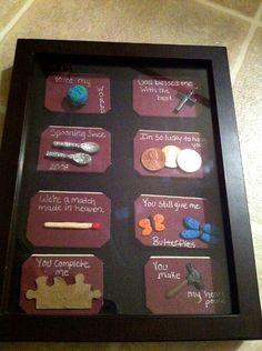 a pinterest frame with pins and magnets in it on a table next to a cell phone