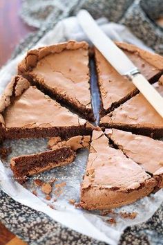 a chocolate cake with one slice cut out and a knife on the plate next to it