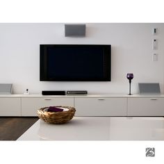 a basket sitting on top of a white table in front of a flat screen tv