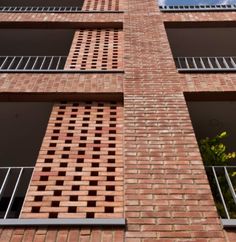 a tall brick building with windows and balconies