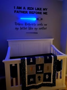 a baby crib with a blue light on the wall above it that reads, i am a bed like my father before me