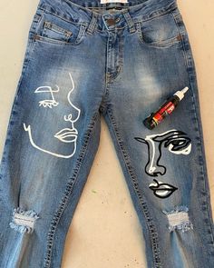 a pair of jeans with faces painted on them