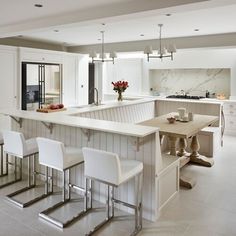 a large kitchen with white cabinets and counter tops, along with stairs leading up to the dining room