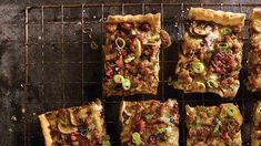 several slices of pizza sitting on top of a cooling rack next to each other with toppings