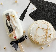 decorated cookies on a table with black and gold confetti, graduation cap and gown