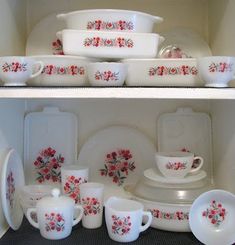 two shelves with dishes and cups on them