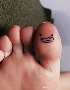 a person's foot with a smiley face drawn on the bottom of their toe