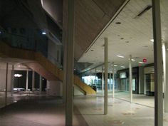 an empty building with some stairs and lights in the middle, at night or early evening