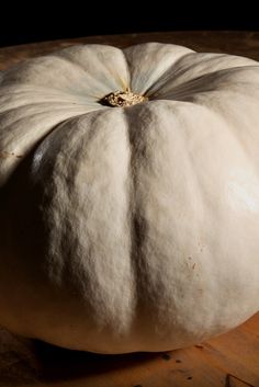 a white pumpkin sitting on top of a wooden table