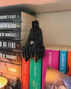 a stack of books sitting on top of each other next to a candle and bookend