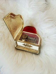 an open box sitting on top of a white furnishing covered floor next to a red heart shaped object