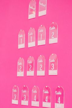 pink table number tags with white numbers on them