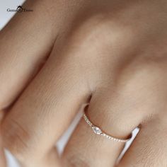 a woman's hand with a diamond ring on top of her finger and the bottom half of her arm