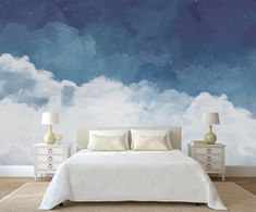 a bedroom with a bed, night sky wallpaper and two lamps on nightstands