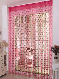 the curtains in this room are pink and white with red dots on them, as well as flowers