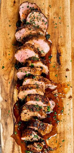 sliced pork on a wooden cutting board with sauce