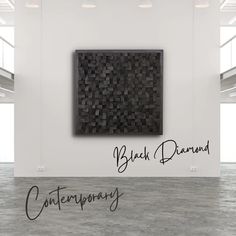 an empty room with a black diamond painting on the wall and words written below it