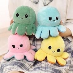 three stuffed animals sitting on top of a bed next to each other in different colors