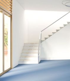 an empty room with blue carpet and stairs