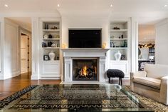 a living room with a fire place and white furniture