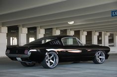 an old black car parked in a parking garage