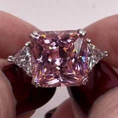 someone is holding a fancy pink diamond in their hand