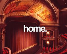 an empty theater with red seats and painted ceiling above the stage is full of people