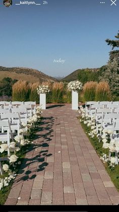 an outdoor ceremony with white chairs and flowers