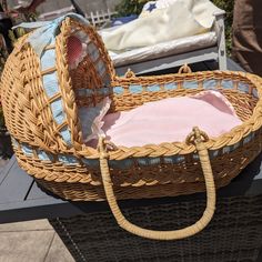 a wicker basket sitting on top of a table next to a person's handbag