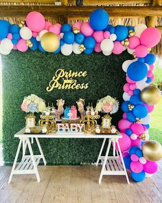 a table topped with balloons and cake next to a sign that says prince princess on it