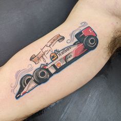 a man's arm with a tattoo of a racing car